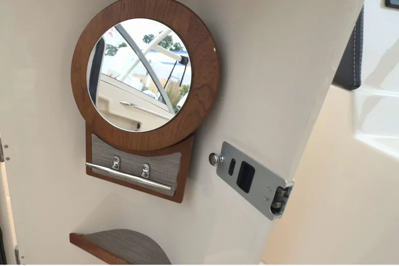 Slide: The Image of 2023 Grady-White Freedom 235 interior with round mirror and storage compartment. - 18