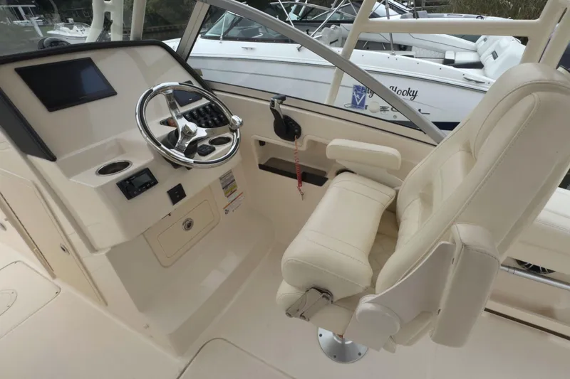 Slide: The Image of 2023 Grady-White Freedom 235 boat cockpit with steering wheel and captain's chair. - 19