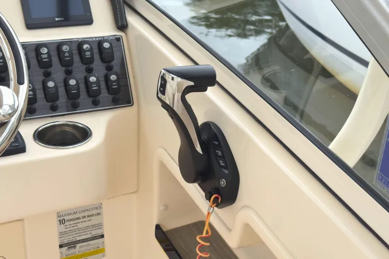 Slide: The Image of Control panel of 2023 Grady-White Freedom 235 boat, featuring throttle and switches. - 21