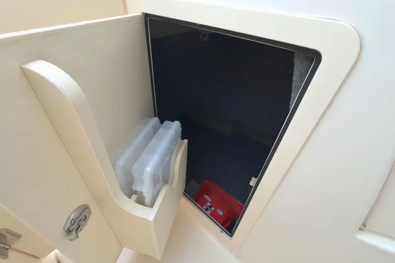 Slide: The Image of Storage compartment on a 2023 Grady-White Freedom 235 boat, featuring organized containers. - 26