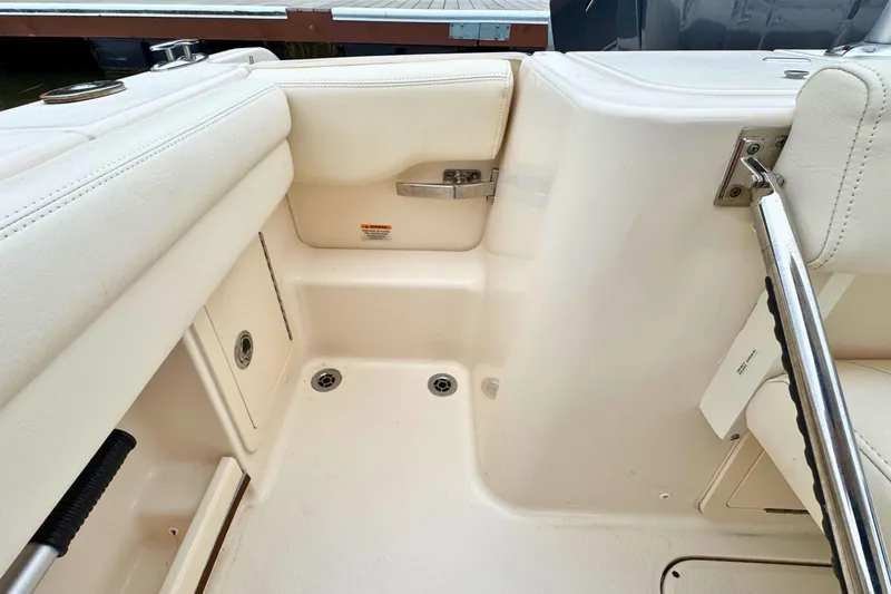 Slide: The Image of 2023 Grady-White Freedom 235 boat interior, featuring white seating and stainless steel fixtures. - 38