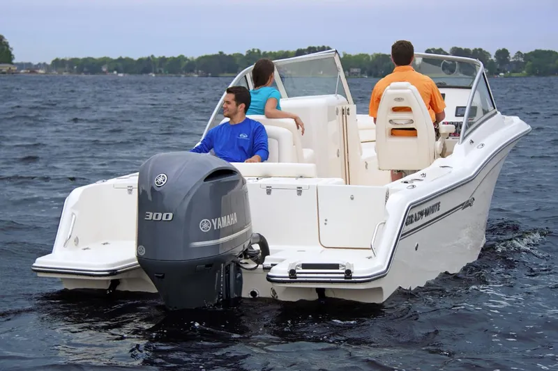 Slide: The Image of 2023 Grady-White Freedom 235 boat on calm water, surrounded by lush greenery. - 4