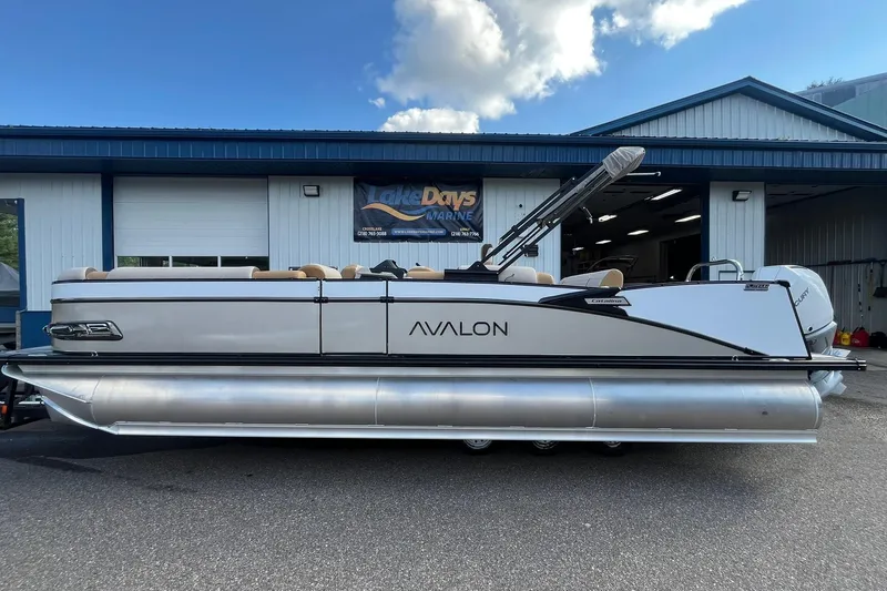 The Image of 2026 Avalon Catalina Versatile Rear Bench pontoon boat parked outside a marine shop. - 1