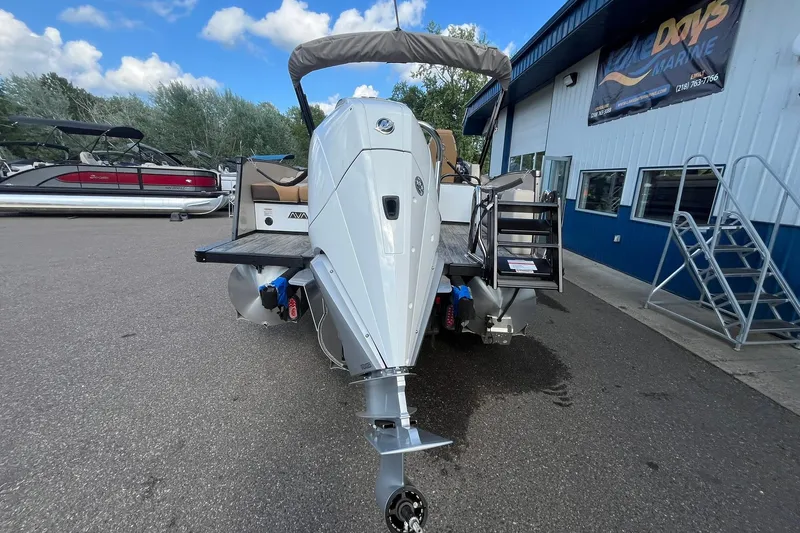 Slide: The Image of 2026 Avalon Catalina Versatile Rear Bench boat with outboard motor, parked at a marina. - 3