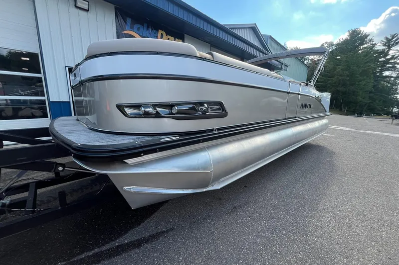 Slide: The Image of 2026 Avalon Catalina Versatile Rear Bench pontoon boat on trailer, parked outdoors. - 7