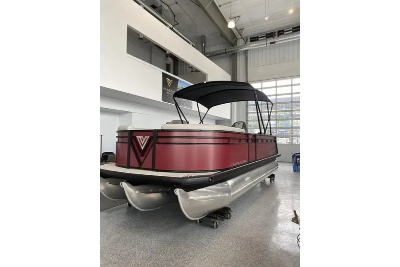 The Image of 2025 Viaggio Lago V-U pontoon boat in showroom, featuring sleek red design and canopy. - 0