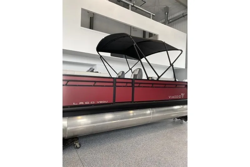 Slide: The Image of 2025 Viaggio Lago V-U pontoon boat with red exterior and black canopy in showroom. - 2