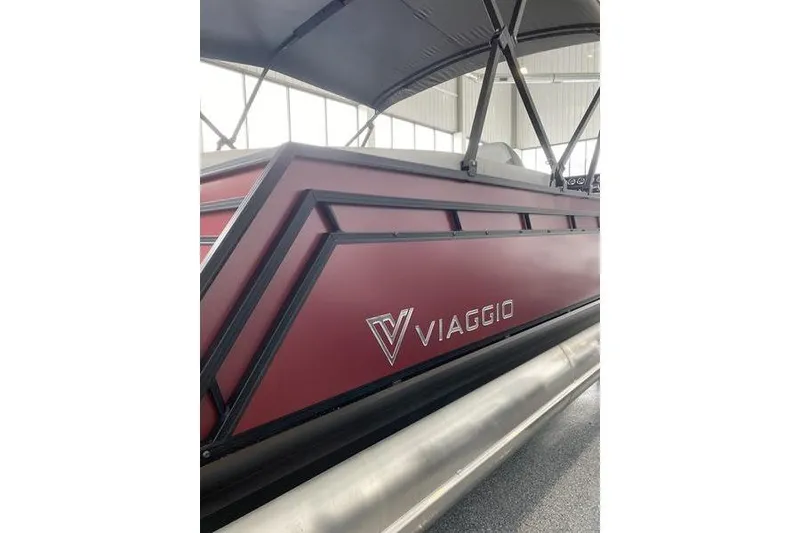 Slide: The Image of 2025 Viaggio Lago V-U pontoon boat with sleek maroon design in showroom. - 6