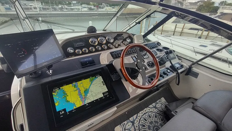 Slide: The Image of 2001 Cruisers Yachts 4450 Express Motoryacht helm with navigation screens and controls. - 14