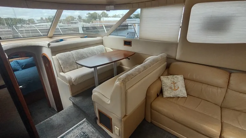 Slide: The Image of Interior of 2001 Cruisers Yachts 4450 Express Motoryacht with beige seating and dining area. - 25