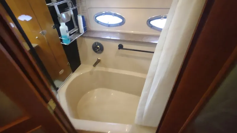 Slide: The Image of Luxurious bathroom in 2001 Cruisers Yachts 4450 Express Motoryacht with oval windows and bathtub. - 35