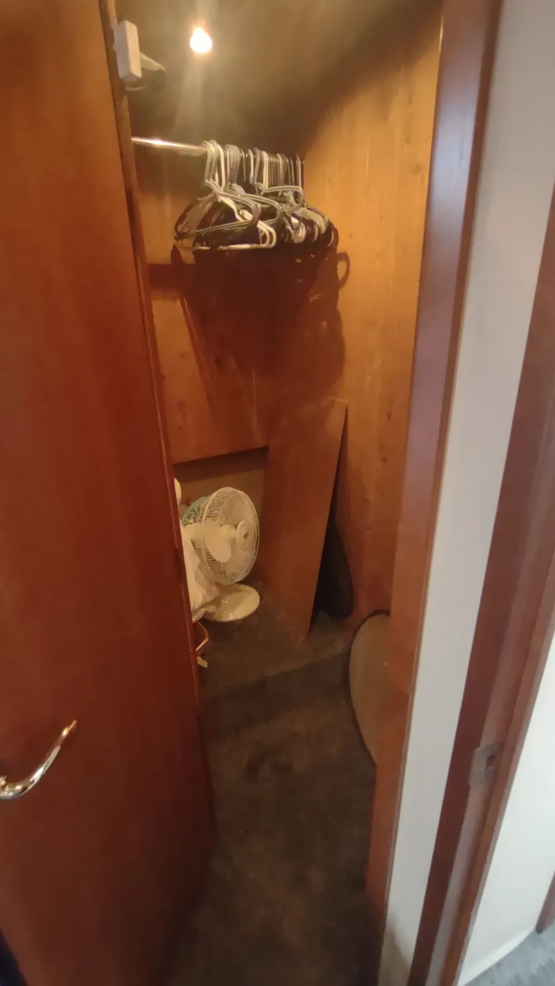 Slide: The Image of Small wooden closet with hangers and a fan inside a 2001 Cruisers Yachts 4450 Express Motoryacht. - 45