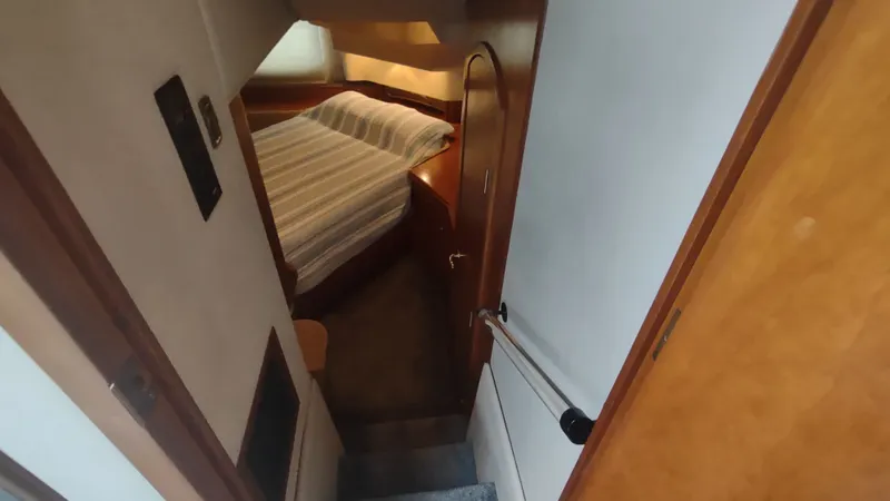 Slide: The Image of 2001 Cruisers Yachts 4450 Express Motoryacht interior cabin with bed and wooden accents. - 30