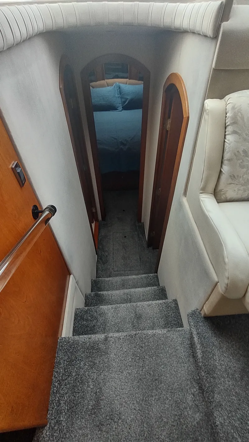 Slide: The Image of Interior stairs of 2001 Cruisers Yachts 4450 Express Motoryacht, leading to a cozy cabin. - 38