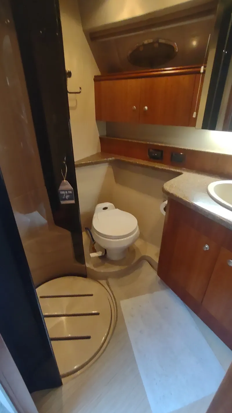 Slide: The Image of 2001 Cruisers Yachts 4450 Express Motoryacht bathroom with shower, toilet, and wooden cabinetry. - 40
