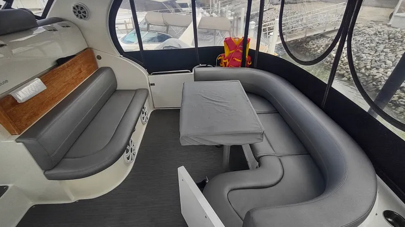 Slide: The Image of 2001 Cruisers Yachts 4450 Express Motoryacht interior with gray seating and table. - 8