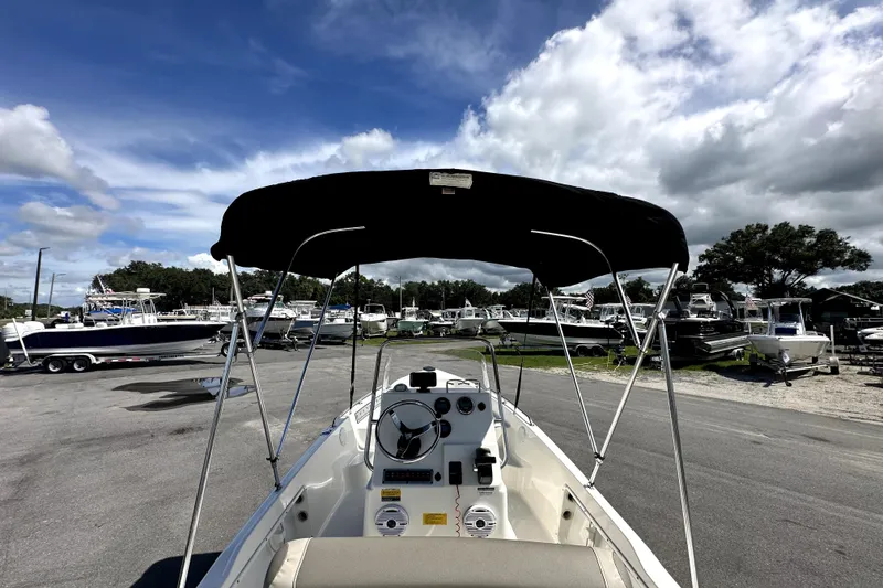 Slide: The Image of 2022 Key West 1720 Center Console boat with canopy in a marina under cloudy sky. - 15