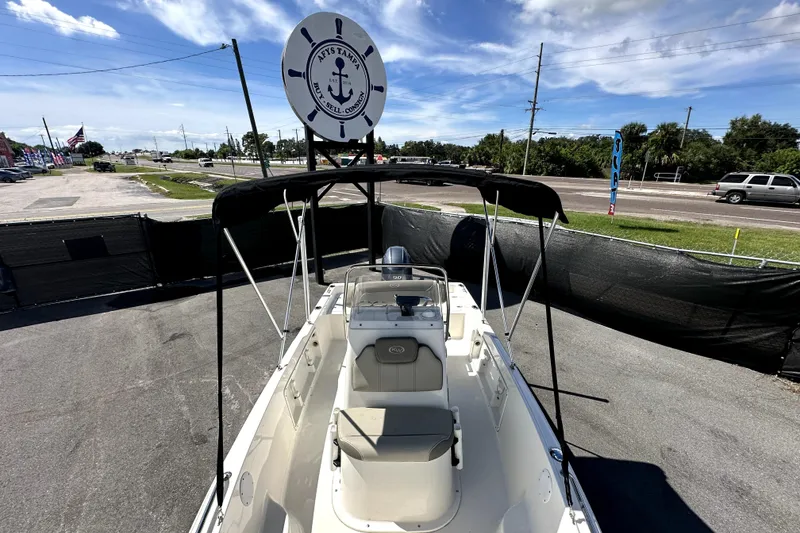 Slide: The Image of 2022 Key West 1720 Center Console boat with canopy, parked outdoors under a clear sky. - 29