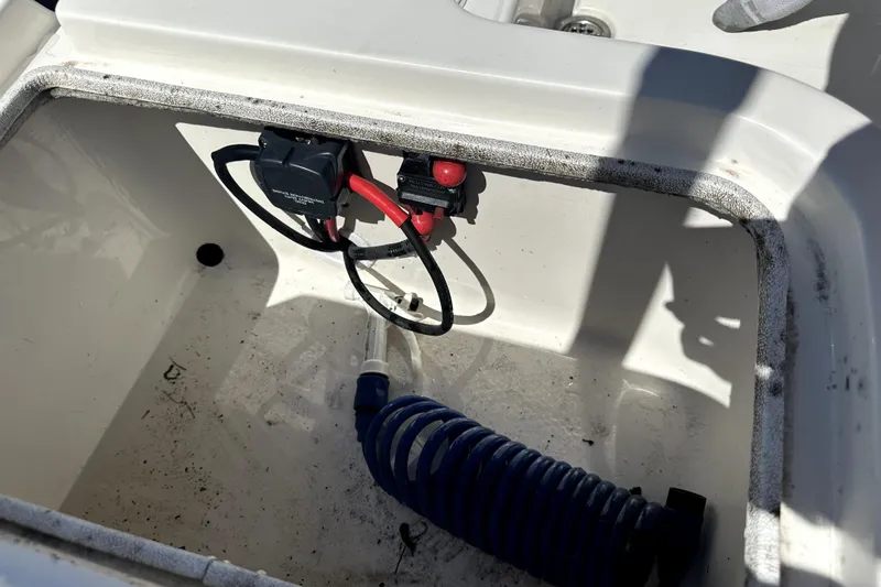 Slide: The Image of 2022 Key West 1720 Center Console boat compartment with coiled hose and wiring. - 44