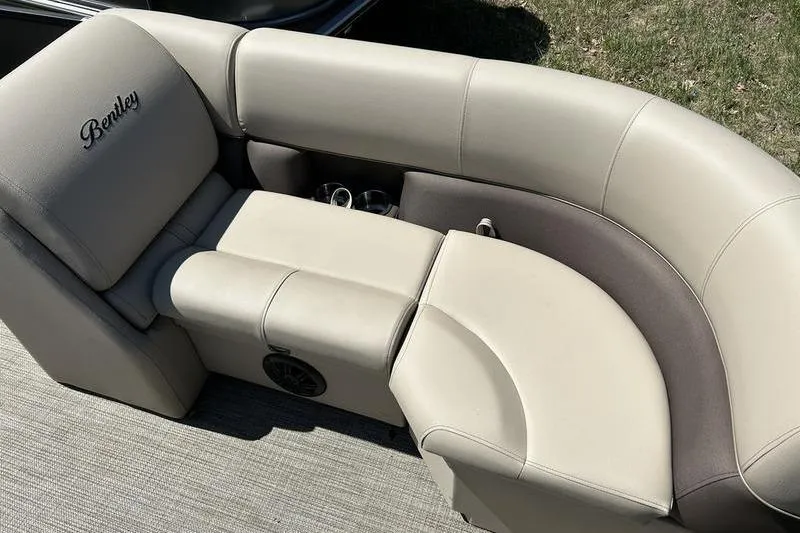 Slide: The Image of 2024 Bentley Pontoons LE 200 CW, luxurious beige seating with cup holders and speaker. - 16