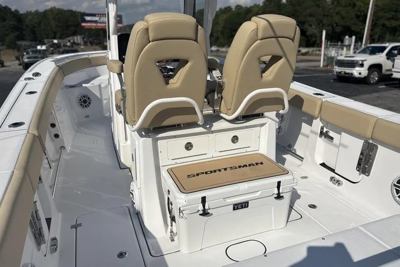 Slide: The Image of 2026 Sportsman Heritage 261 Center Console boat interior with beige seating and Yeti cooler. - 16
