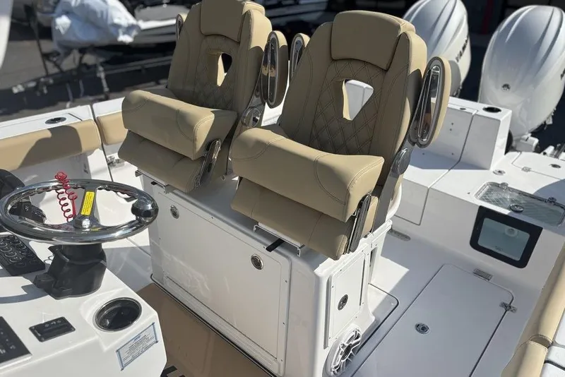 Slide: The Image of 2026 Sportsman Heritage 261 Center Console with dual tan captain's chairs and steering wheel. - 22