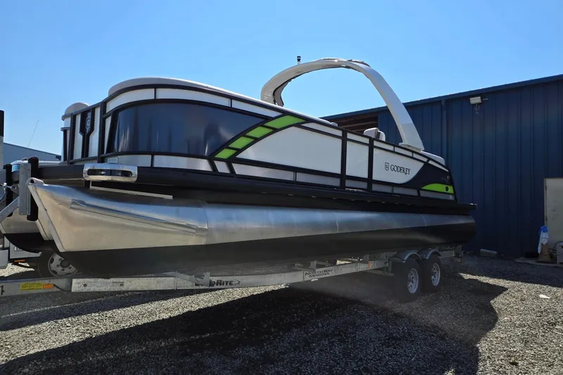 The Image of 2025 Godfrey Monaco 255 SB pontoon boat on trailer, parked outdoors. - 0
