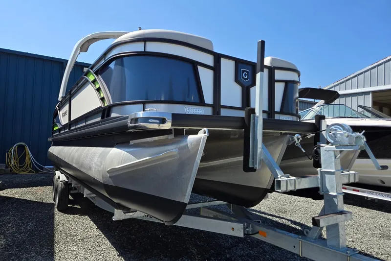 Slide: The Image of 2025 Godfrey Monaco 255 SB pontoon boat on trailer, parked outdoors. - 10