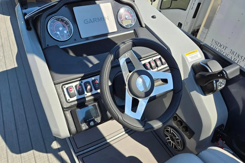 Slide: The Image of 2025 Godfrey Monaco 255 SB boat dashboard with Garmin display and steering wheel. - 18