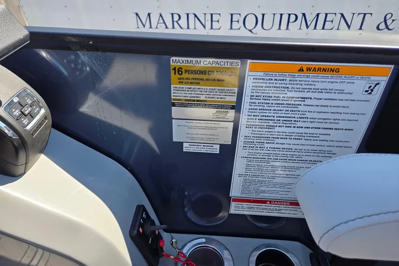 Slide: The Image of Control panel and safety warnings on a 2025 Godfrey Monaco 255 SB boat. - 22