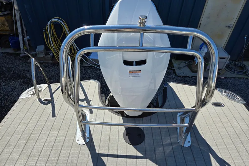 Slide: The Image of 2025 Godfrey Monaco 255 SB boat with stainless steel railing and outboard motor. - 26