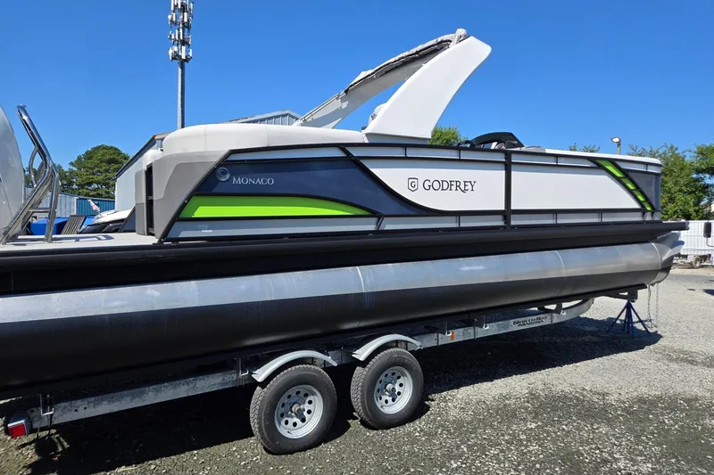 Slide: The Image of 2025 Godfrey Monaco 255 SB pontoon boat on trailer, side view, outdoors. - 6