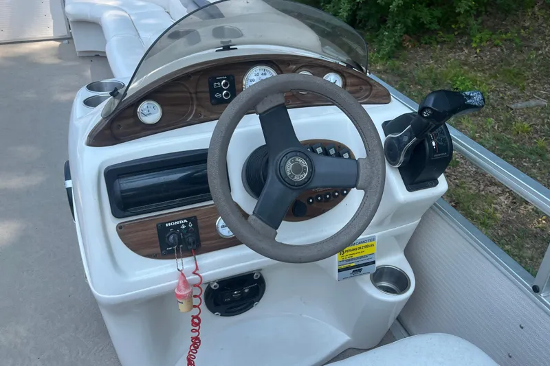 Slide: The Image of 2007 Harris-Kayot Super Sunliner 220 O/B boat dashboard with steering wheel and controls. - 14