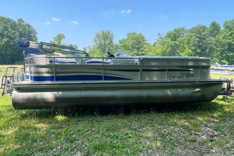Slide: The Image of 2007 Harris-Kayot Super Sunliner 220 O/B pontoon boat on grassy area, surrounded by trees. - 6
