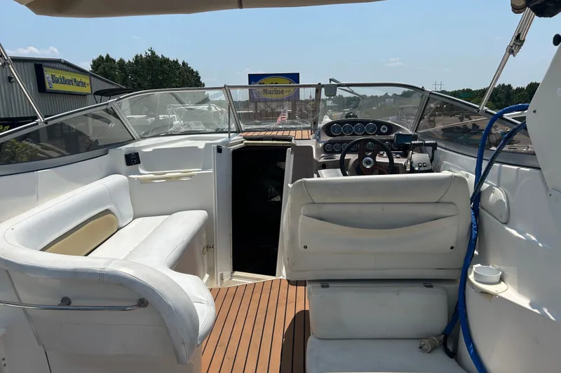 Slide: The Image of 2003 Regal Commodore 2860 boat interior with white seating and wooden deck. - 11