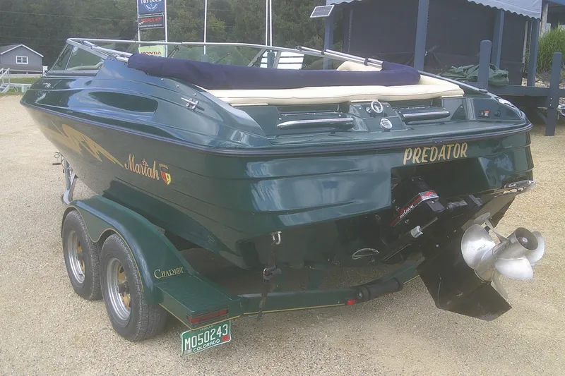 Slide: The Image of 1997 Mariah Z 210 Shabah boat on trailer, green exterior, dual propeller, parked outdoors. - 19