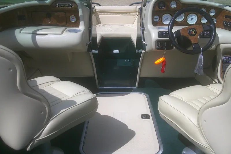 Slide: The Image of Interior of a 1997 Mariah Z 210 Shabah boat with beige seating and dashboard. - 8