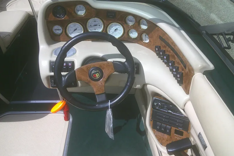 Slide: The Image of 1997 Mariah Z 210 Shabah boat dashboard with wood accents and steering wheel. - 9