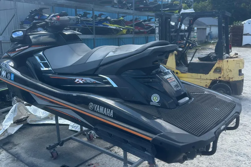 Slide: The Image of 2016 Yamaha WaveRunner FX HO jet ski in a storage area, black with orange accents. - 6