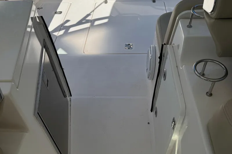 Slide: The Image of 2016 Pursuit DC 325 Dual Console boat interior with open door and seating area. - 11