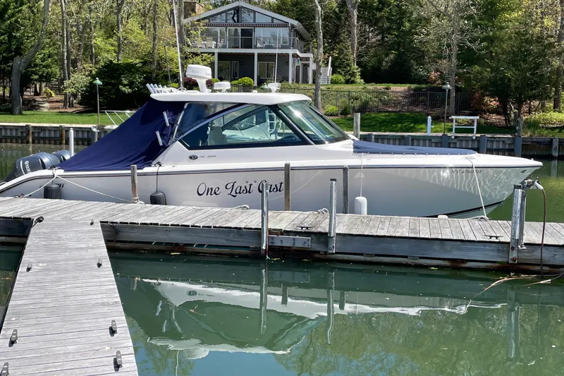 Slide: The Image of 2016 Pursuit DC 325 Dual Console boat docked, featuring twin Yamaha engines. - 2