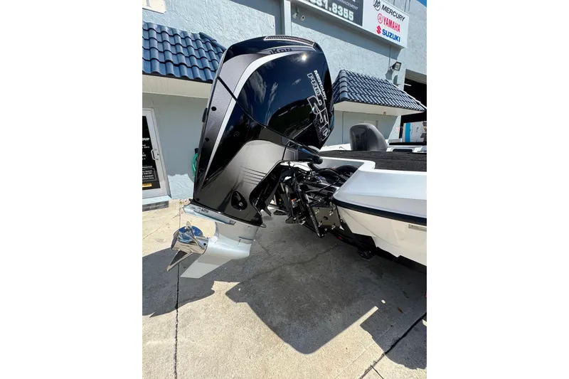 Slide: The Image of 2026 iKon VLE20 boat with powerful outboard motor, parked outside a marine service shop. - 22