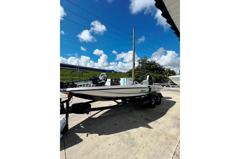 Slide: The Image of 2026 iKon VLE20 boat on trailer outside marine dealership under clear blue sky. - 3