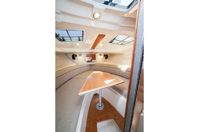 Slide: The Image of 2026 Cutwater C-248 Coupe interior with modern seating and wooden table. - 15