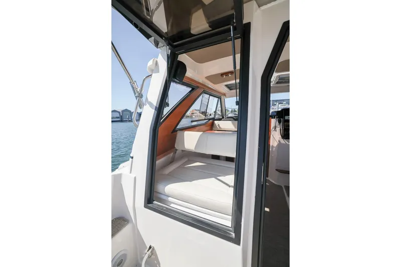 Slide: The Image of 2026 Cutwater C-248 Coupe interior view with seating and windows, docked by the water. - 19