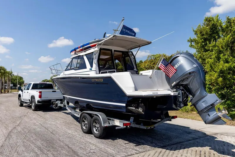 Slide: The Image of 2026 Cutwater C-248 Coupe boat on trailer, hitched to a white truck, sunny day. - 5