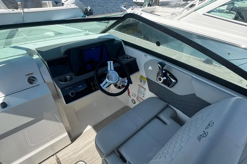 Slide: The Image of 2025 Sea Ray SDX 250 Outboard helm with steering wheel and control panel. - 11