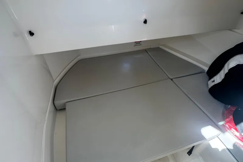 Slide: The Image of 2025 Sea Ray SDX 250 Outboard interior cabin with compact toilet and seating area. - 13