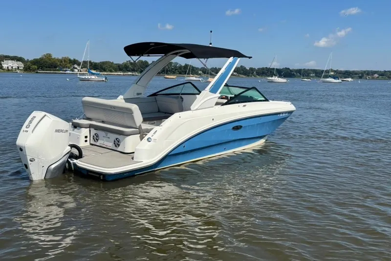Slide: The Image of 2025 Sea Ray SDX 250 Outboard boat on calm water with cityscape background. - 5