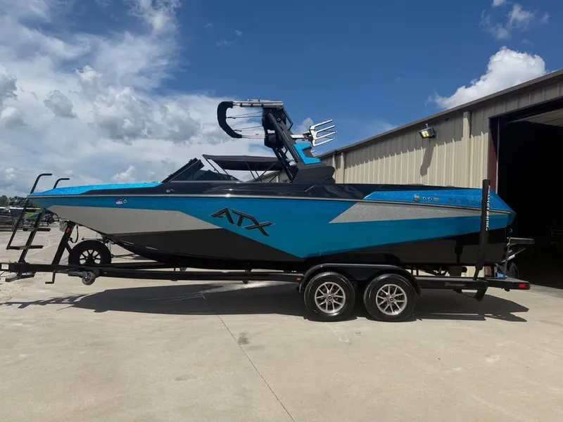 Slide: The Image of 2023 ATX Surf Boats 24 Type-S in blue on trailer, parked outdoors. - 3